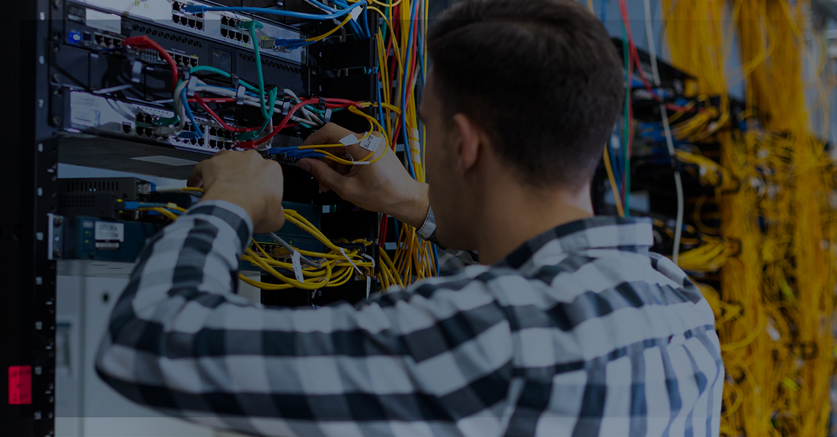 Homem na sala de servidores realizando manutenção na rede | Outsourcing: como ele pode ajudar a área de TI