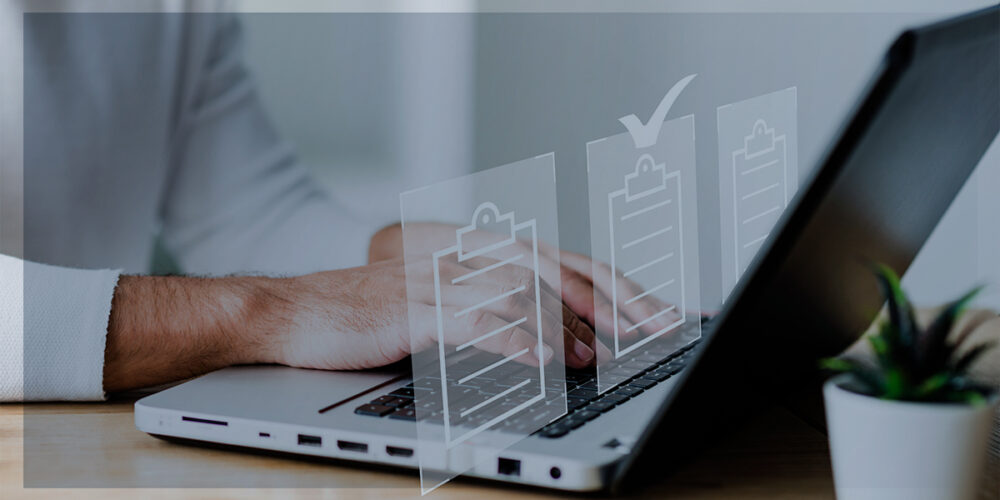 Pessoa digitando em um notebook com ícones transparentes de checklists flutuando à frente da tela, simbolizando digitalização e organização de documentos.