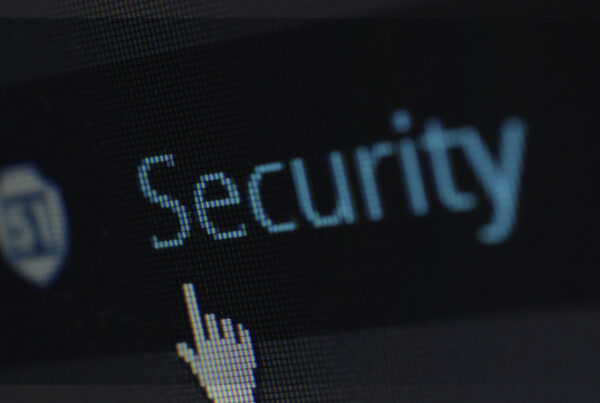 Close na tela de um computador exibindo a palavra “Security” com ícone de escudo e cursor, simbolizando segurança da informação e proteção de dados pessoais.